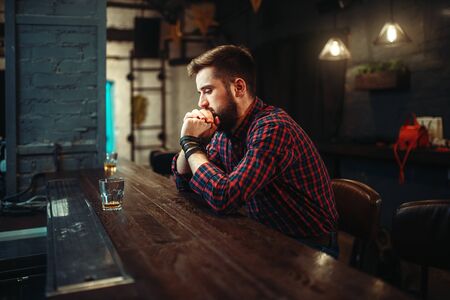 Man sitting at the bar counter and drink alcoholの写真素材