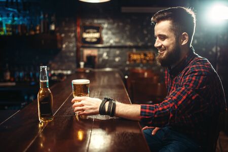 One bearded man drinks beer at the bar counterの写真素材