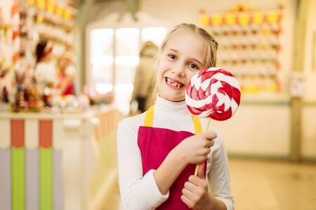 Little girl holds handmade sugar caramel on stickの写真素材