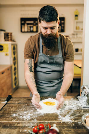 Pasta cooking, bearded chef preparing doughの写真素材