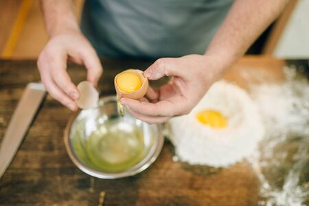 Pasta cooking process, male chef hands with eggの写真素材