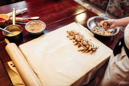 Male chef sprinkle the dough with cinnamonの写真素材