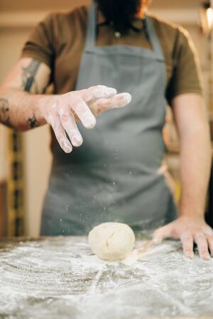 Fresh pasta cooking, chef in apron makes dough