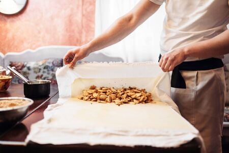 Chef wraps the filling into dough, apple strudelの写真素材
