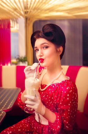 Sexy pin up girl drinks milkshake through a straw