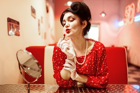 Sexy pin up woman with bright lipstick in handの写真素材