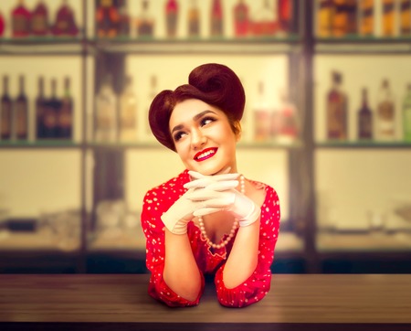 Sexy pin up girl stands behind the bar counterの写真素材