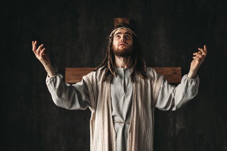 Great martyr praying, cross on black background