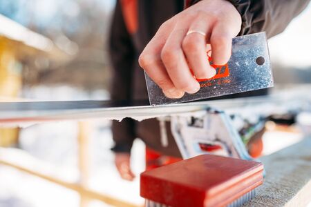 Male skier serves skis before skiing, winter sport