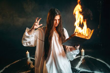 Woman sitting in burning pentagram circle, magic