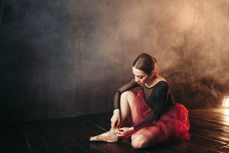 Ballet dancer tying pointe shoesの写真素材