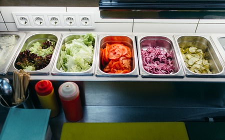 Metal pallets with ingredients for burger cooking