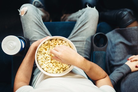Male person with popcorn in cinema, top view
