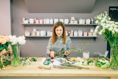 Female florist prepares flower compositionの写真素材