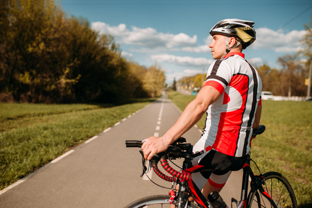 Cyclist in sportswear, cycling on asphalt roadの写真素材