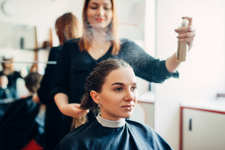 Hairdresser works with hair spray, hairdressingの写真素材