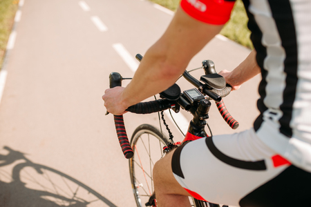 Male cyclist in sportswear cycling on asphalt roadの写真素材