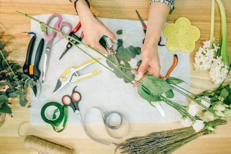 Florist prepares flower composition, top view