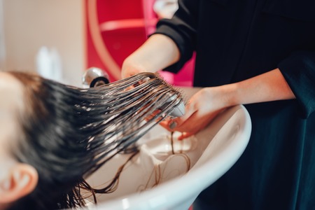 Hairdresser washes hair in hairdressing salonの写真素材