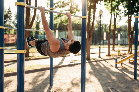 Man doing exercise on press using horizontal barの写真素材