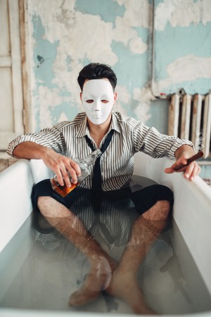 Drunk businessman sitting in bathtub, suicide manの写真素材