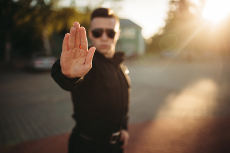 Serious police officer shows a hand stop signの写真素材
