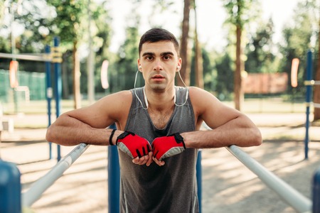Man doing exercise on parallel bars, front view