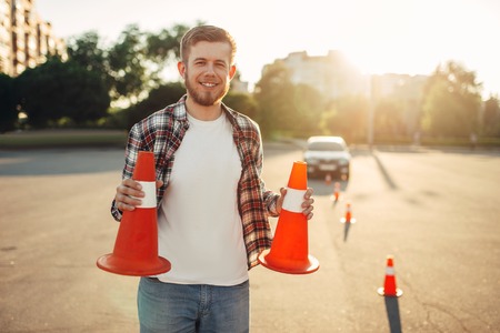 Male vehicle instructor holds cones in handsの写真素材