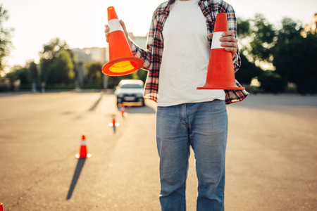 Male vehicle instructor holds cones in handsの写真素材