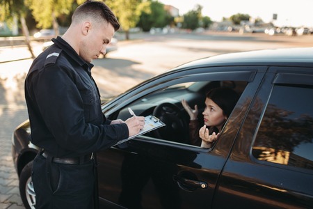 Male police officers check vehicle on the roadの写真素材