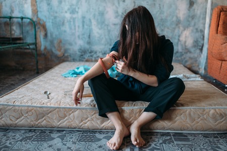 Drug addict with a syringe doing an injection doseの写真素材