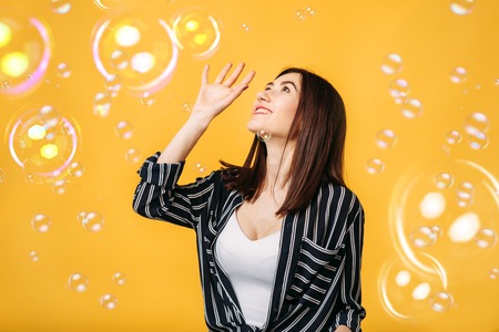 Pretty woman catches soap bubble