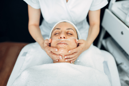 Face massage to female patient, cosmetology clinicの写真素材