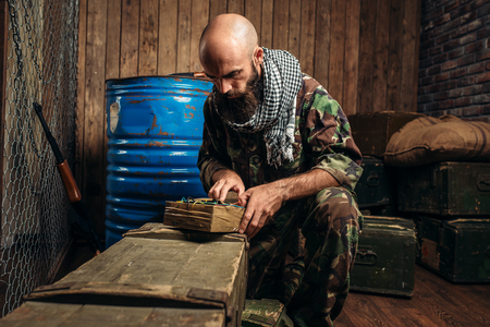 Bearded terrorist in uniform cooking a bombの写真素材