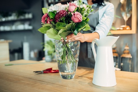 Florist making flowers arrangement in shopの写真素材