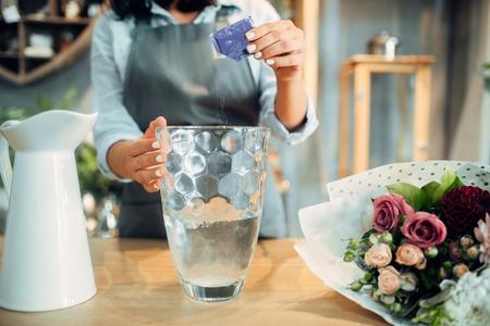 Florist adds fertilizer to the water for flowersの写真素材