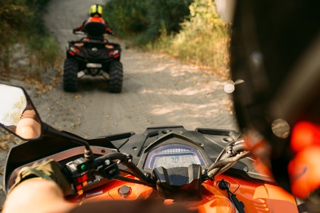 Atv riding in action, view through the eyes of the driver. Two riders on quad bikes having offroad adventure in forestの写真素材