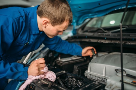 Male technician checks brake fluid level in carの写真素材