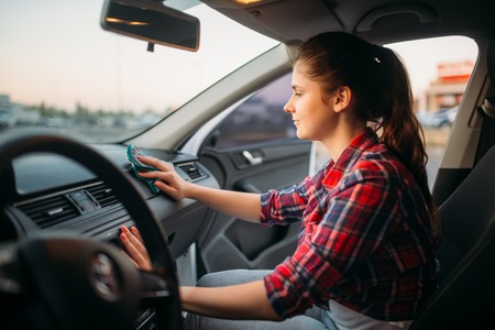 Woman polishes the torpedo on car washの写真素材