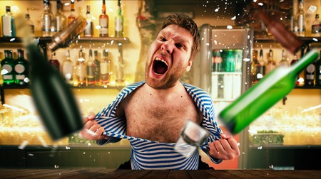 Drunk bartender tears his vest at the bar counterの写真素材