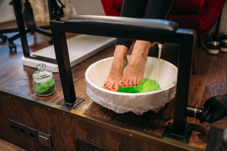Female client feet in a pedicure bath, top viewの写真素材