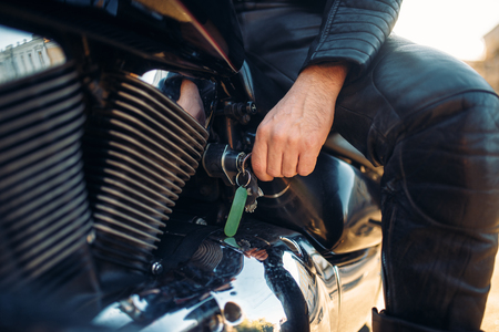 Biker inserts the key in the ignition of chopperの写真素材
