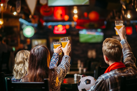 Group of football fans watching match in sport barの写真素材