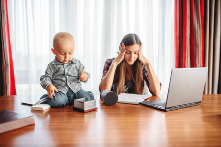 Mother works, kid helps her, motherhood problemsの写真素材