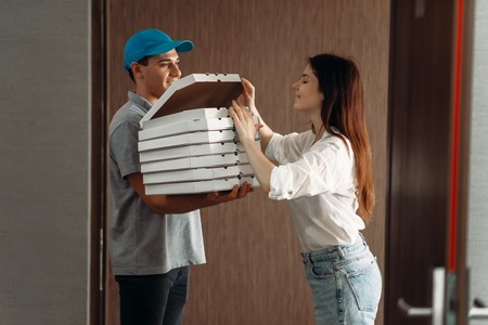 Delivery boy shows pizza to female customer