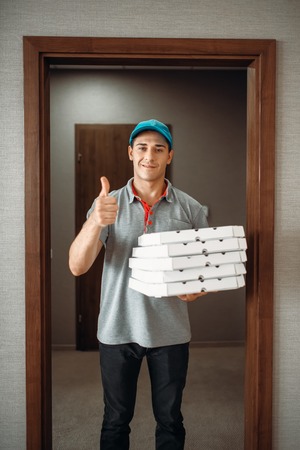 Cheerful pizza delivery boy shows Ok symbol