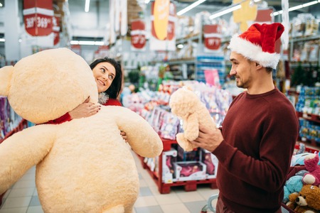 Young couple choosing plush toys in supermarketの写真素材