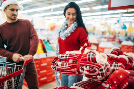 Couple buying christmas costume in supermarketの写真素材