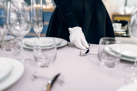 Waitress in gloves puts the knife, table settingの写真素材