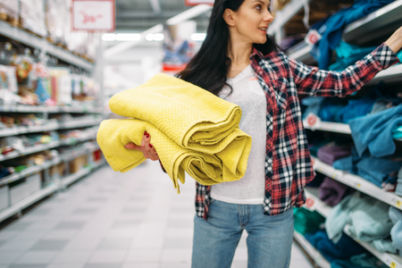 Young woman buying towels in supermarketの写真素材